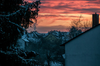 rötlicher Morgenhimmel über Häusern